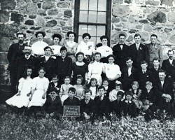 A school photo from 1910. This is not the same building pictured in the previous photo. <br><br>This earlier stone school was built in 1870 and used until 1915, when the new school was completed. Class photo