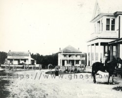 Eldorado main street around 1916 showing the three stores.<br><br>The dark store on the right was operated by James Deremo and later Fred Vandervoort. The big white store beside it was built in 1915 by E.A. Strebe. The store across the road (still standing) was erected by G.R. Jones. To the left is the former post office. Townsite
