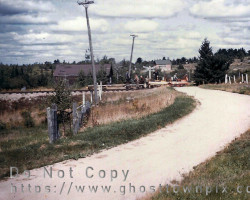 Lifting the tracks. The schoolhouse can be seen in the background. ca. 1955 Town view