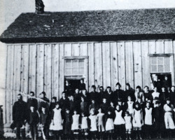 Class photo in front of the first schoolhouse, ca. 1886-87 Group photo
