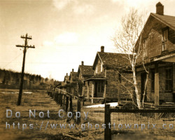 A block of former homes. Some of the old power lines are still up. Others hang on the ground. The building in the foreground is being used as an office building, ca. 1947 Photo of houses